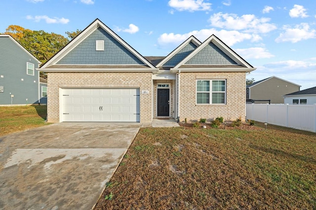 craftsman house featuring an attached garage, brick siding, fence, driveway, and a front lawn