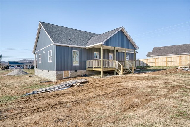 back of property with roof with shingles, crawl space, and fence