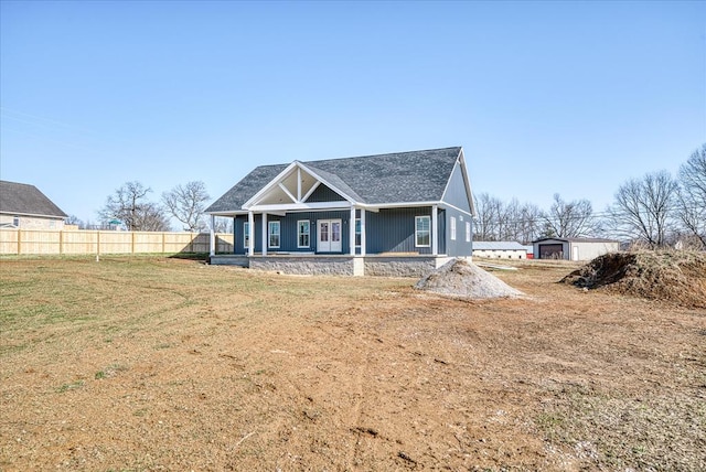 view of front facade with a porch, a front yard, and fence