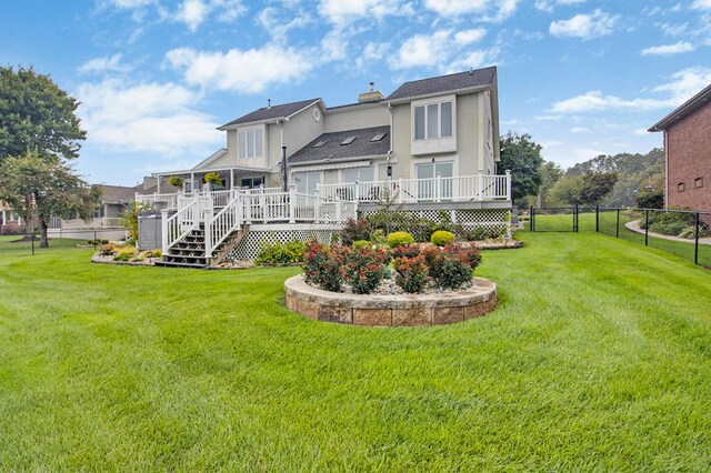 rear view of property with stairway, fence, a deck, and a yard