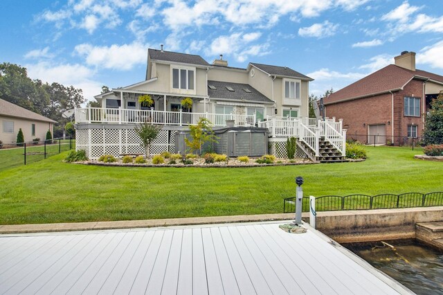 rear view of property featuring a yard, fence, a chimney, and a wooden deck