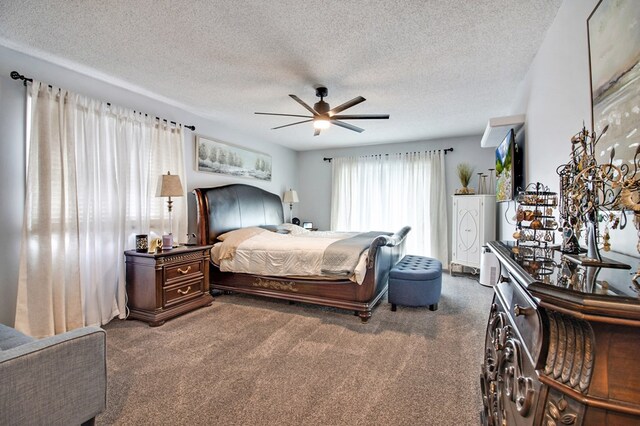 bedroom featuring a ceiling fan, dark colored carpet, and a textured ceiling