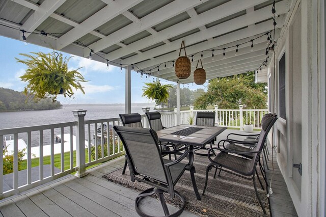 deck featuring outdoor dining space and a water view