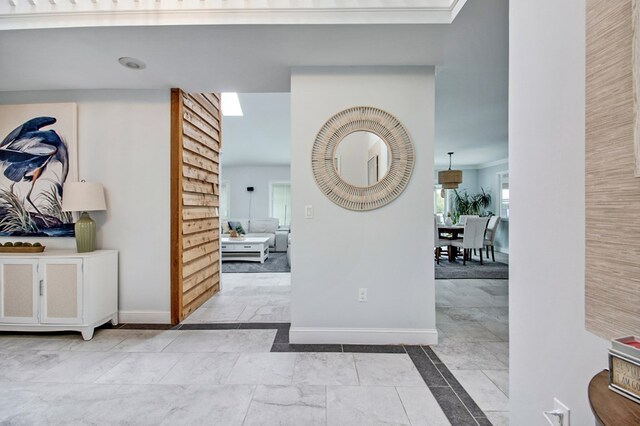 hallway with ornamental molding and baseboards