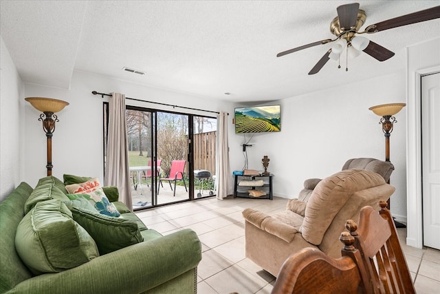 living room featuring a textured ceiling, light tile patterned floors, and visible vents