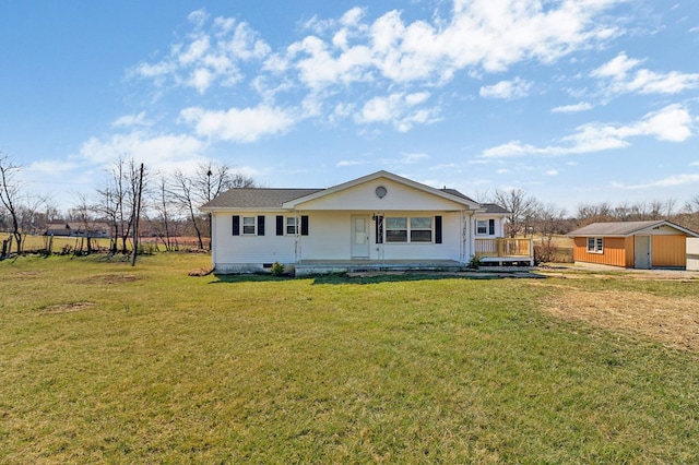 view of front of home with a front yard, an outbuilding, and a shed