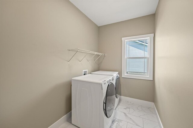 washroom with laundry area, washer and clothes dryer, baseboards, and marble finish floor