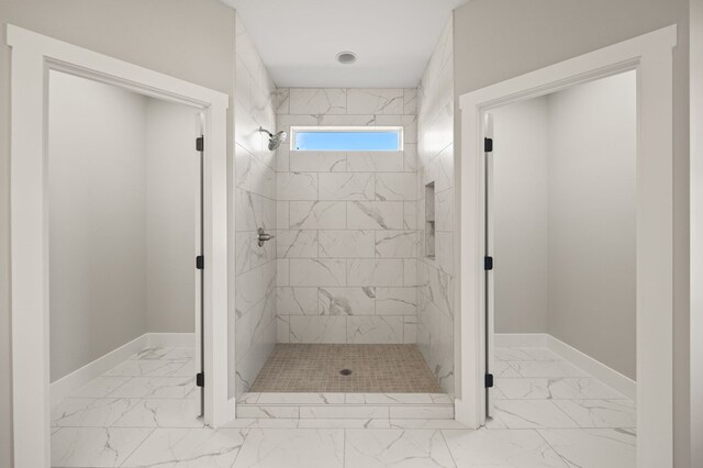 bathroom featuring a stall shower, marble finish floor, and baseboards