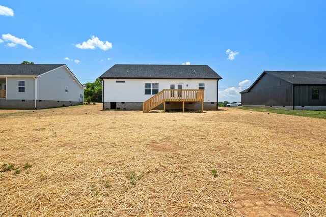 rear view of house with a deck, stairway, crawl space, and a lawn