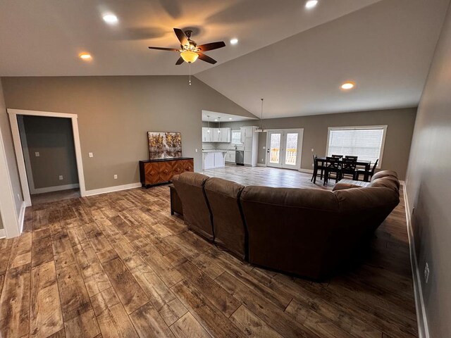 living room with recessed lighting, vaulted ceiling, dark wood finished floors, and baseboards