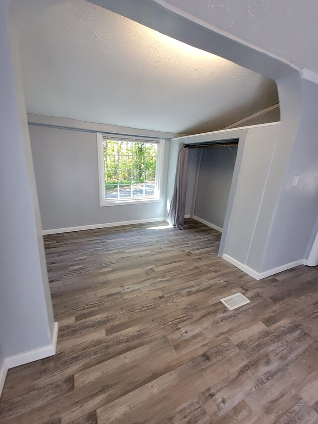 unfurnished bedroom featuring dark wood-type flooring, visible vents, and baseboards