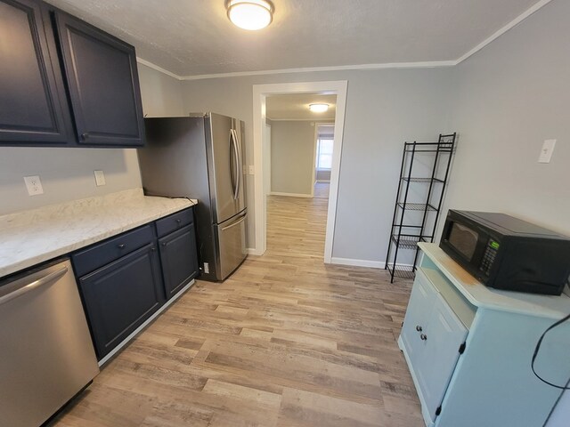 kitchen featuring stainless steel appliances, baseboards, light wood-style floors, light countertops, and crown molding