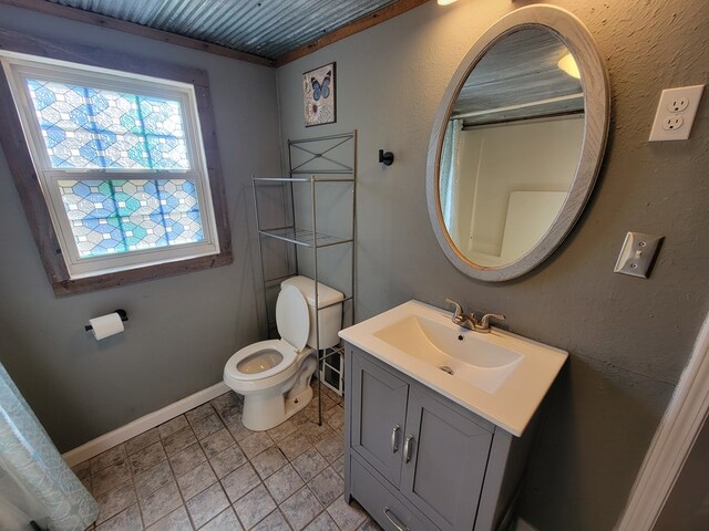 bathroom with toilet, baseboards, and vanity