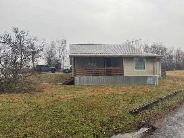 view of home's exterior featuring metal roof and a lawn