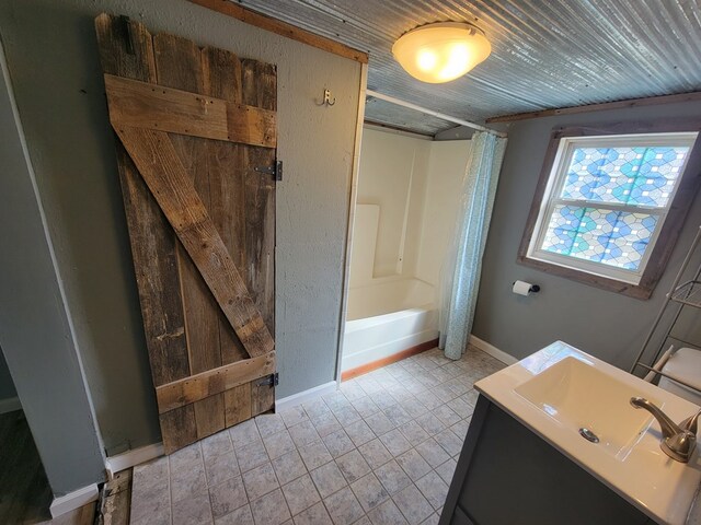 bathroom with baseboards, wood ceiling, tile patterned flooring, shower / bath combination with curtain, and vanity