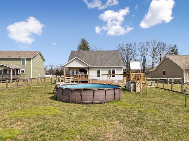 view of swimming pool featuring a fenced backyard, a fenced in pool, a deck, and a lawn