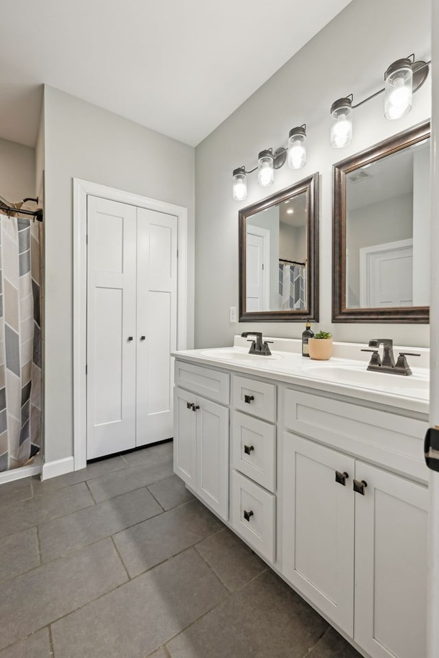 bathroom featuring double vanity, curtained shower, and a sink