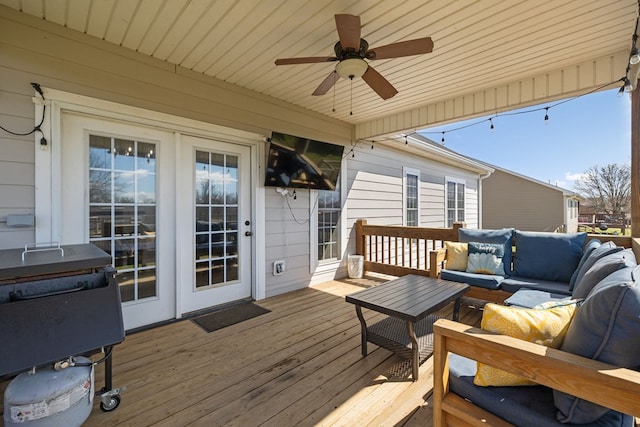 wooden deck with outdoor lounge area and a ceiling fan