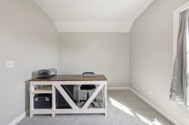 carpeted home office featuring lofted ceiling and baseboards