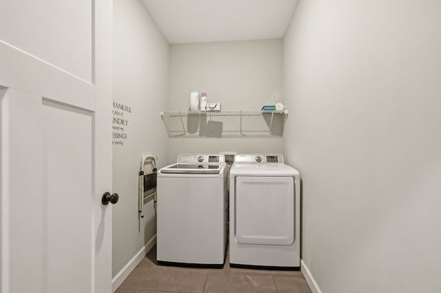 clothes washing area with laundry area, light tile patterned floors, baseboards, and separate washer and dryer