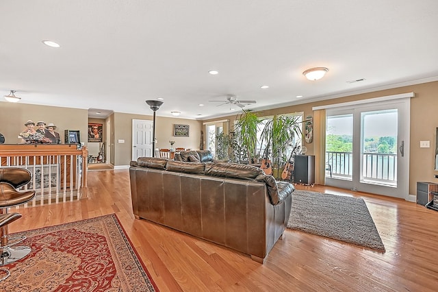 living room with visible vents, crown molding, baseboards, recessed lighting, and light wood-style floors