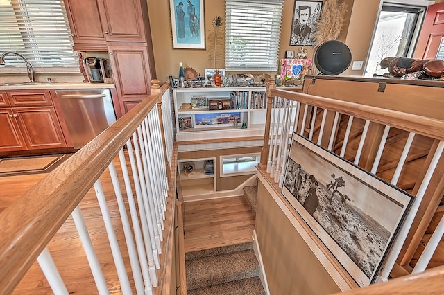 stairway featuring a healthy amount of sunlight and wood finished floors