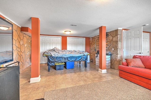 game room with visible vents and a textured ceiling