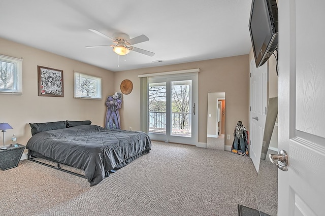 carpeted bedroom with visible vents, multiple windows, and access to outside