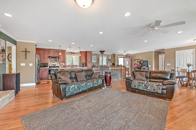 living room with recessed lighting, crown molding, light wood-style floors, and ceiling fan