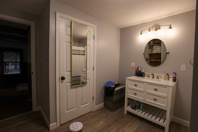 full bathroom featuring vanity, baseboards, and wood finished floors