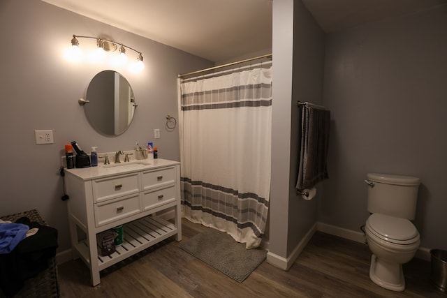 bathroom with vanity, wood finished floors, toilet, and baseboards