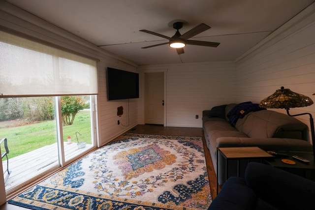 living room featuring ceiling fan, ornamental molding, and wood finished floors