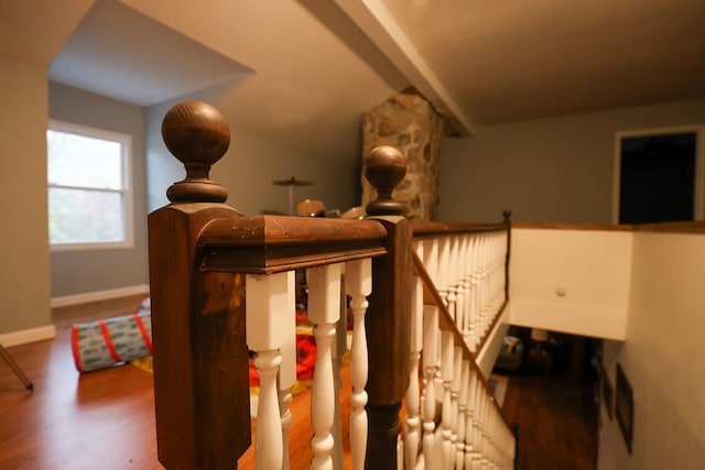 bedroom featuring vaulted ceiling with beams, baseboards, and wood finished floors