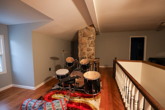 game room with dark wood-style floors, vaulted ceiling, and baseboards