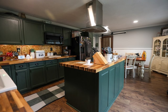 kitchen featuring island exhaust hood, a barn door, a kitchen island, fridge with ice dispenser, and butcher block countertops