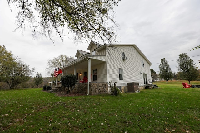 view of side of property with a yard and central AC