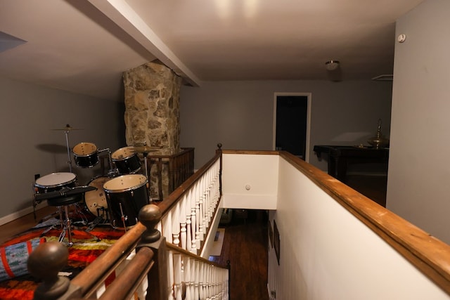 stairs with beamed ceiling, wood finished floors, and baseboards