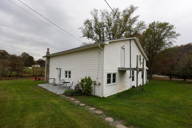 view of side of property featuring a yard and a patio area