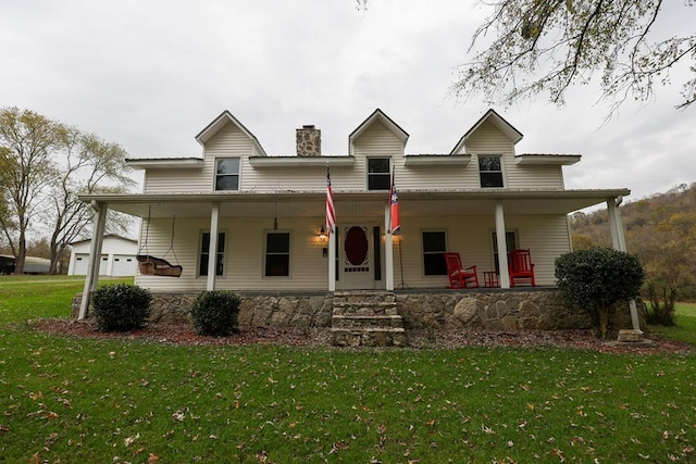 view of front of home with a front yard, covered porch, and a chimney