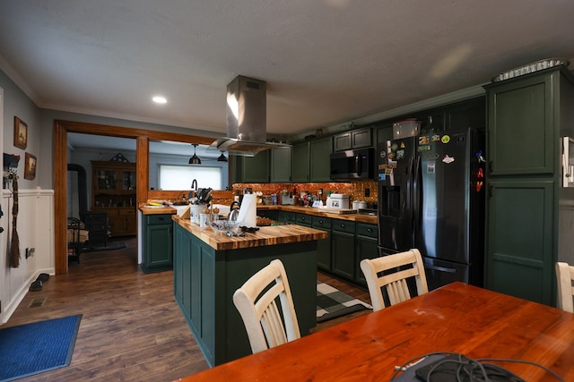 kitchen featuring island range hood, butcher block counters, a kitchen island, stainless steel microwave, and black refrigerator with ice dispenser