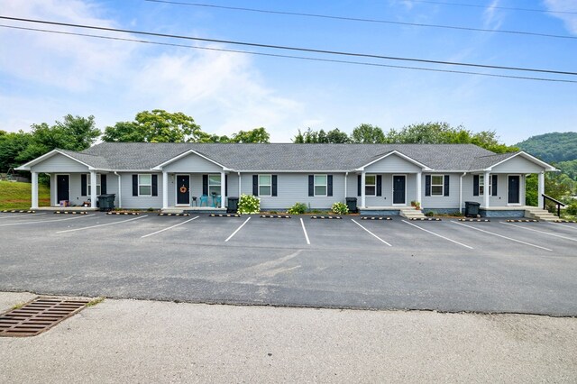 single story home featuring uncovered parking and a porch