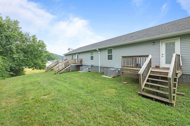 back of property featuring central AC, a shingled roof, a yard, stairway, and a wooden deck