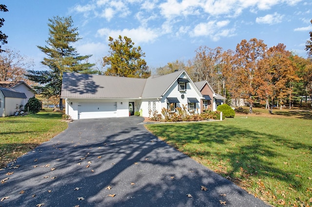 view of front of property featuring a garage, a front lawn, and aphalt driveway