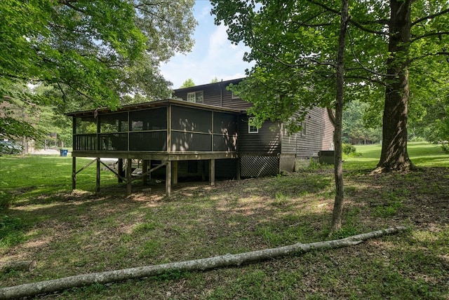 back of property with a yard and a sunroom