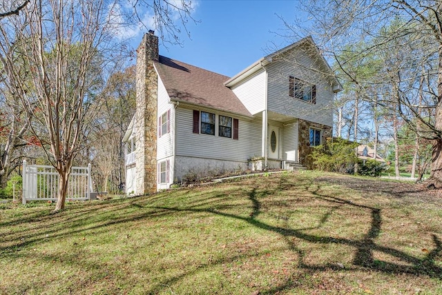 view of front of property with a chimney and a front lawn