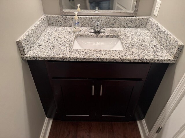 bathroom featuring baseboards, wood finished floors, and vanity