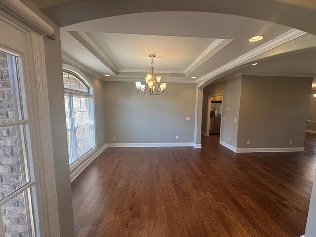 kitchen featuring light stone countertops, a peninsula, dark wood-style flooring, stainless steel appliances, and crown molding