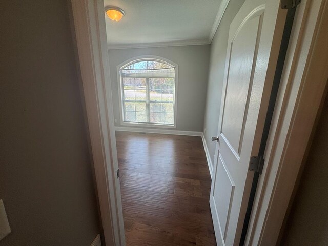 unfurnished room with dark wood finished floors, visible vents, crown molding, and baseboards