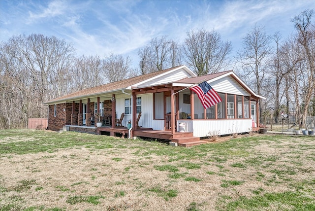 ranch-style home with a porch, a front yard, and a sunroom