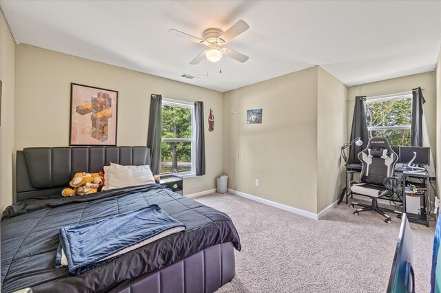 bedroom with baseboards, multiple windows, visible vents, and light colored carpet